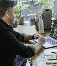 man in black sweater using macbook pro