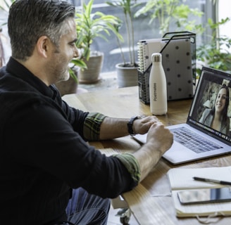 man in black sweater using macbook pro