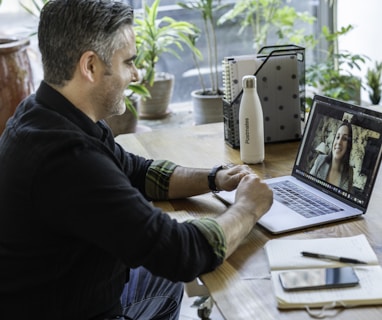 man in black sweater using macbook pro