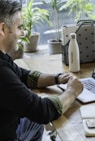 man in black sweater using macbook pro