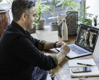 man in black sweater using macbook pro