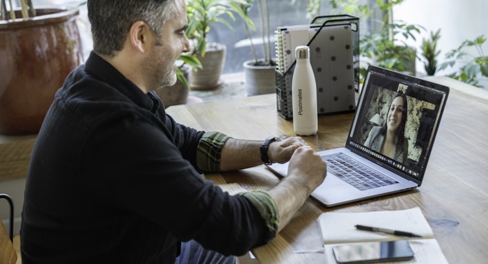 man in black sweater using macbook pro