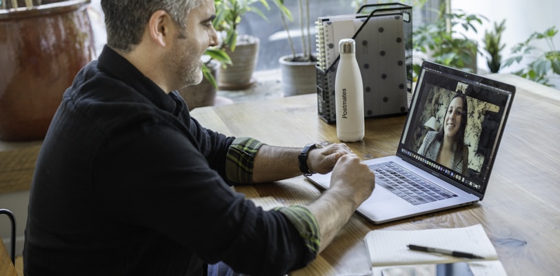 man in black sweater using macbook pro