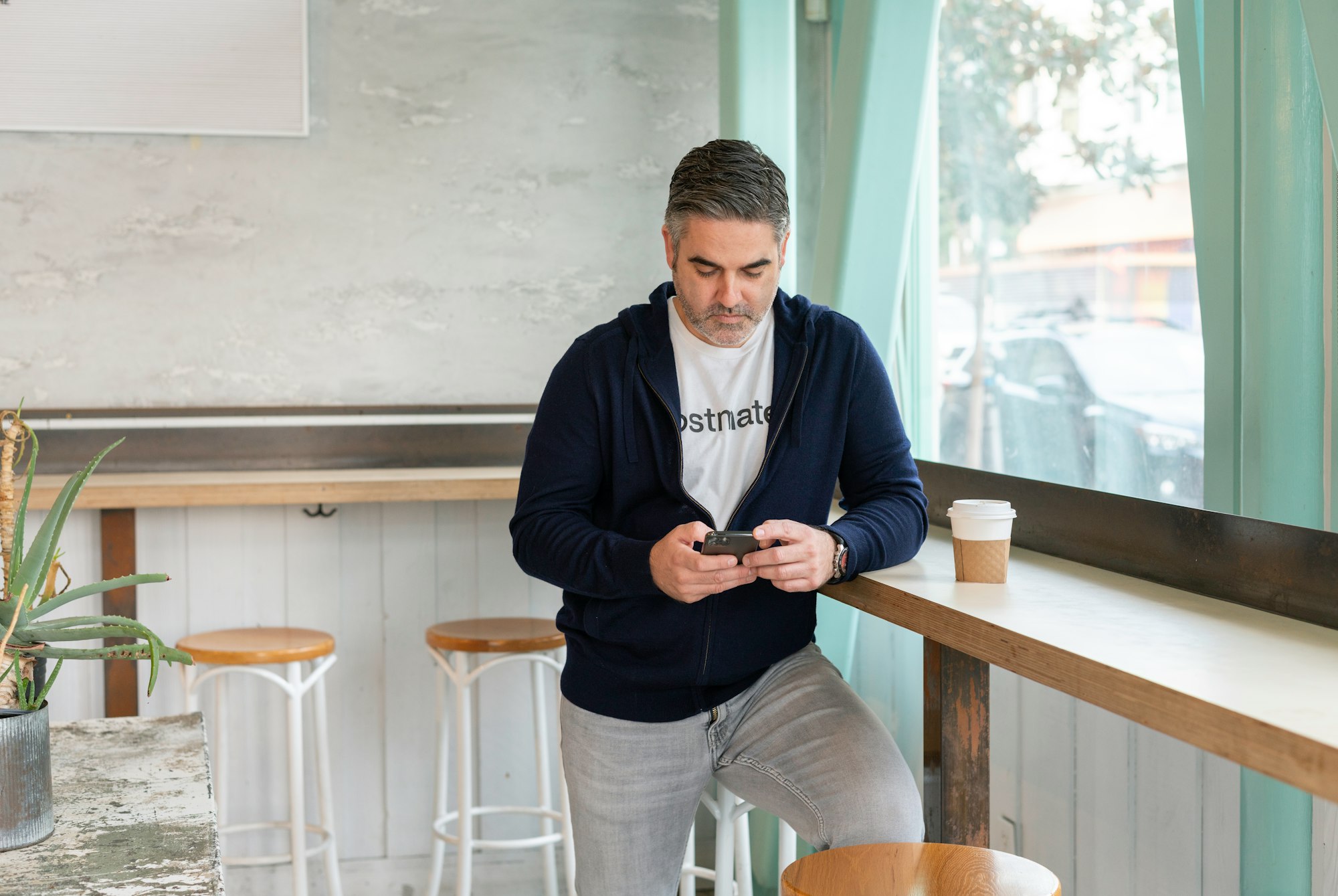 A salesperson checking work phone in a coffee shop