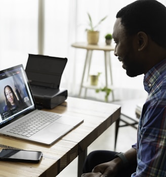 man in blue and white plaid dress shirt using macbook pro