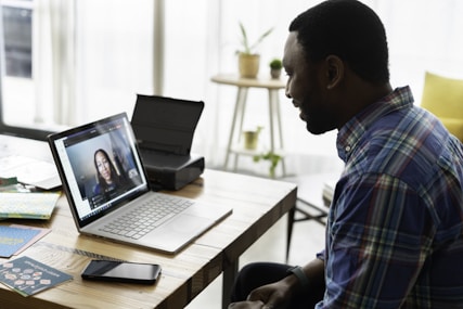 man in blue and white plaid dress shirt using macbook pro