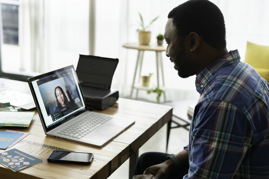 A man at a desk on a video consultation with a clinician