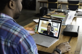 man in blue and white plaid shirt using macbook pro