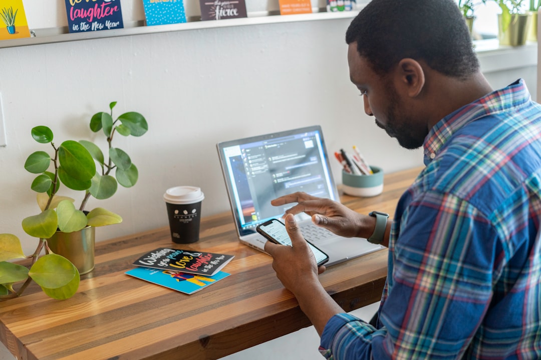 man in blue and red plaid dress shirt using silver ipad