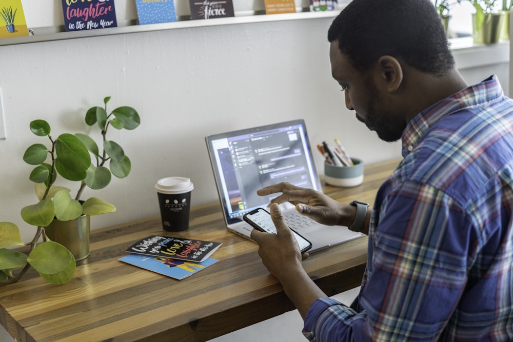 man in blue and red plaid dress shirt using silver ipad