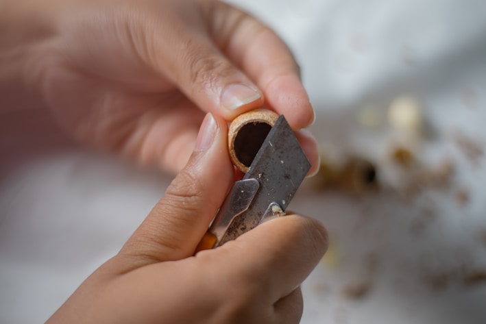 Close-up of a wooden ghani pressing fresh groundnuts to extract pure oil.