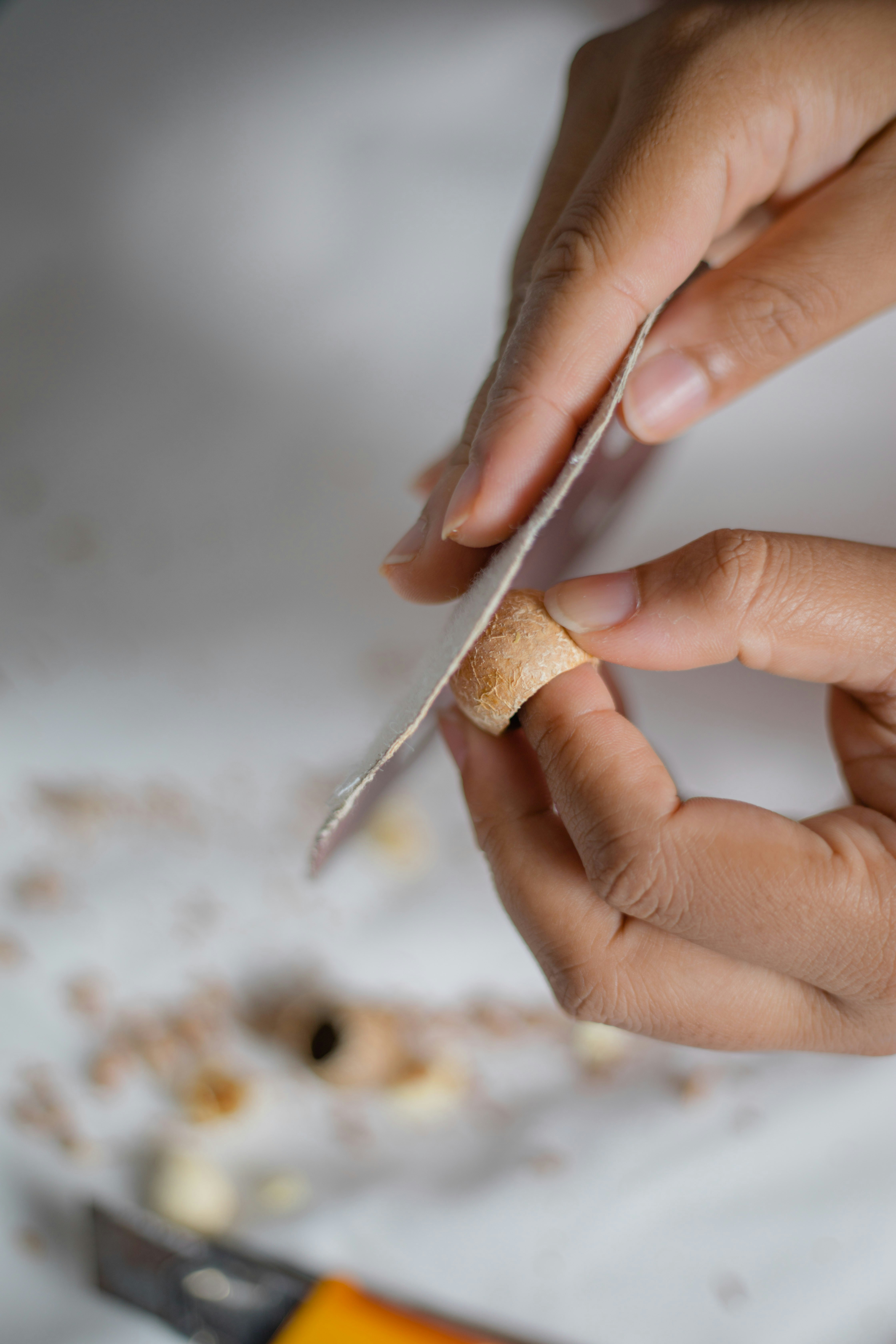 person holding brown stick with white powder