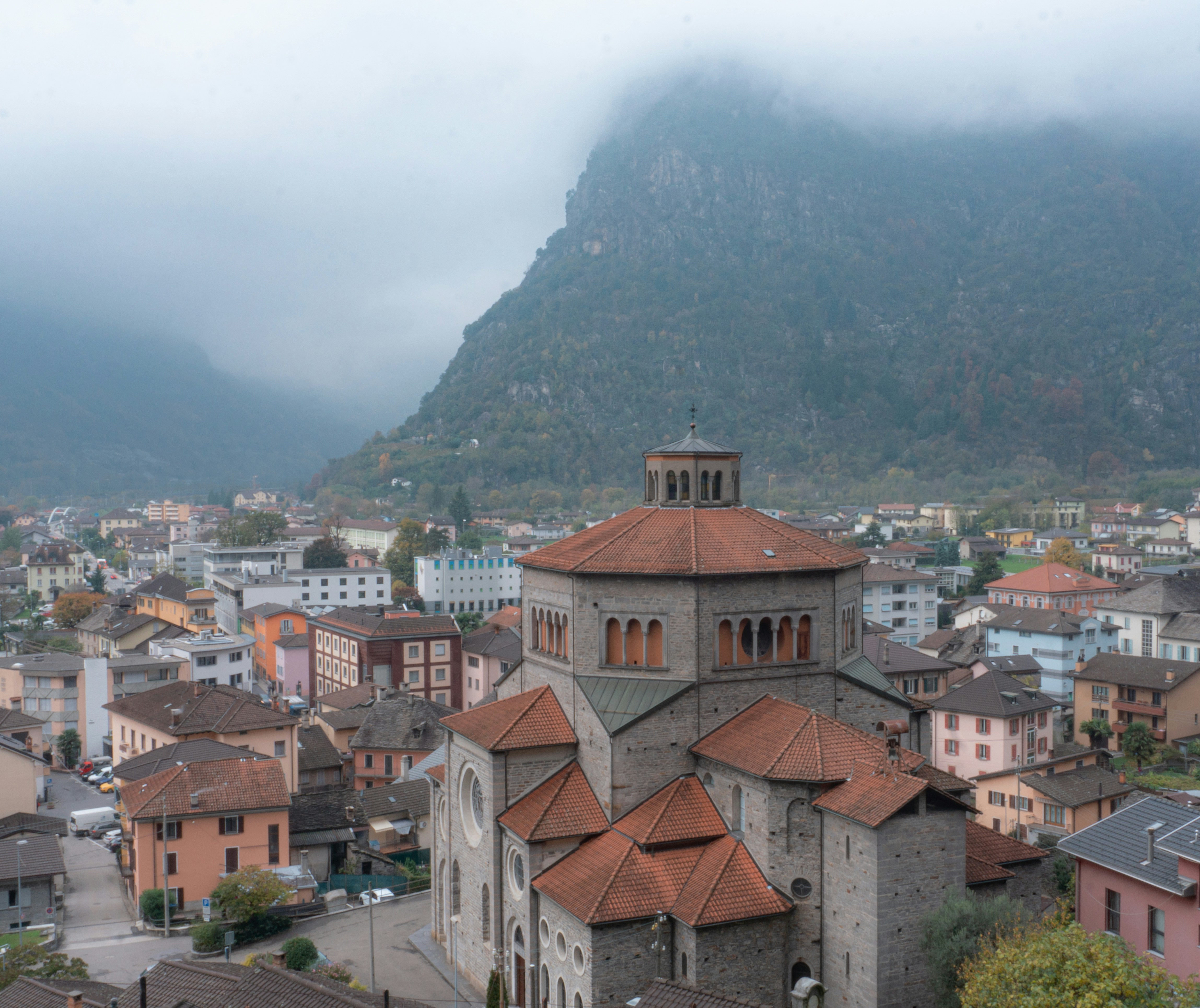 brown and white concrete houses near green mountain during daytime, 
