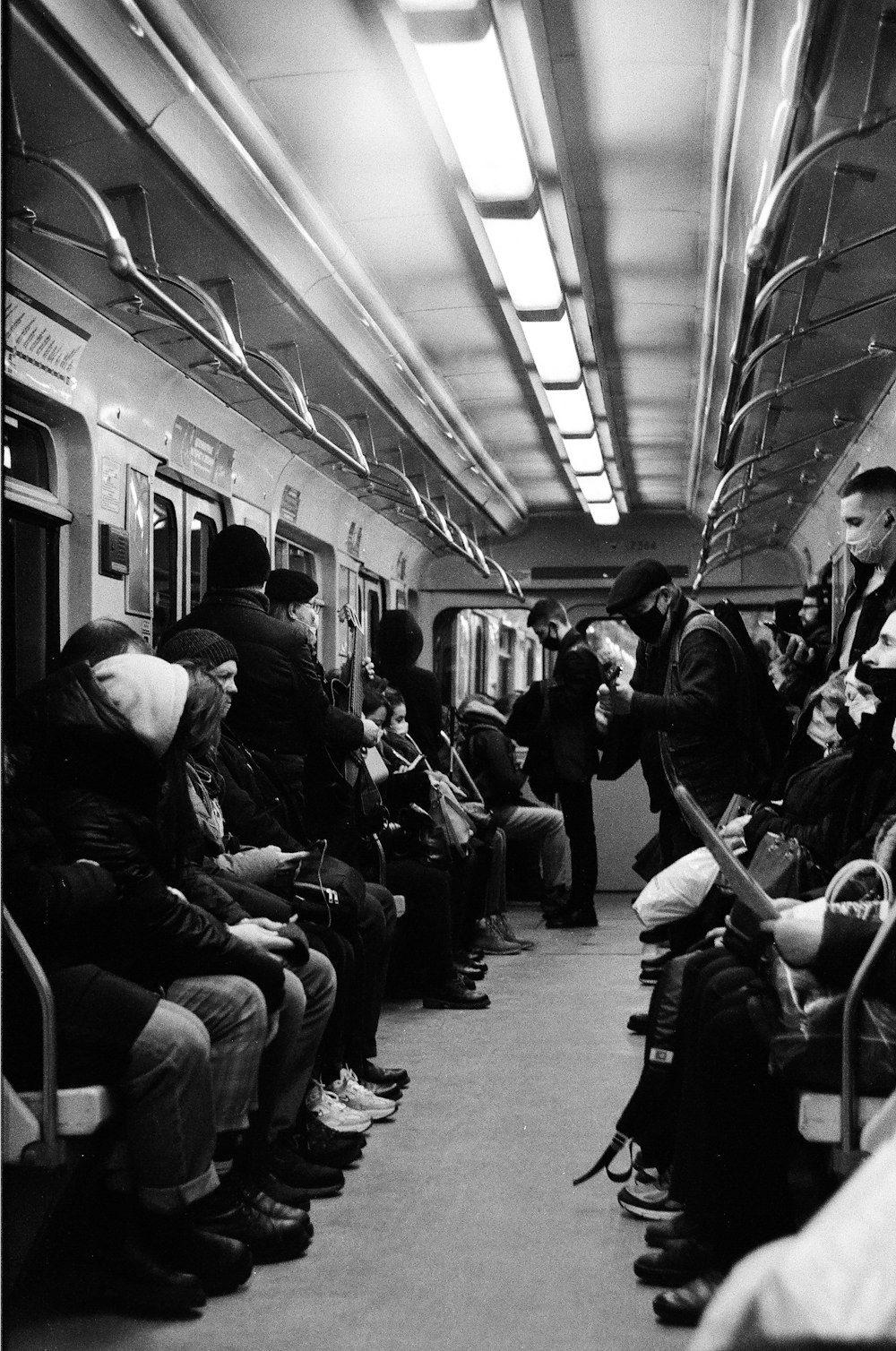 grayscale photo of people sitting on train