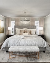 A luxurious bedroom with a plush bed and ambient lighting.