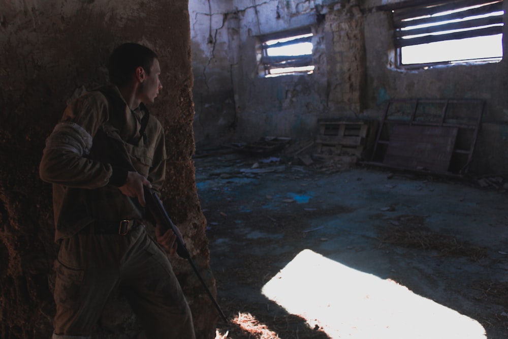 man in brown and black camouflage uniform sitting on concrete floor