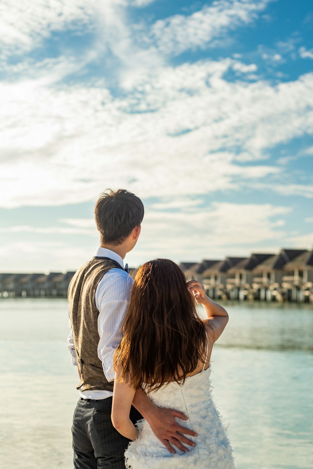 man and woman kissing near body of water during daytime