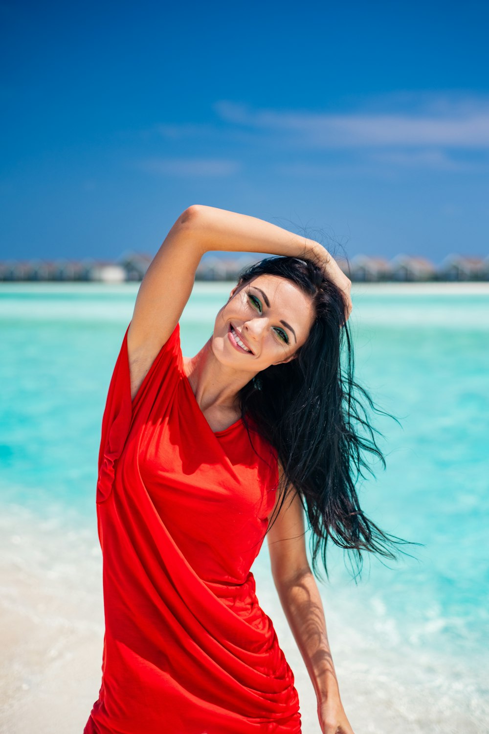 woman in red shirt standing on beach during daytime