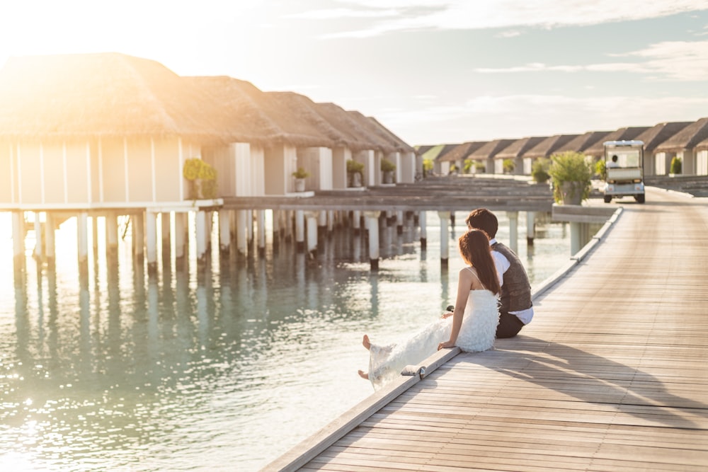 woman in white shirt sitting on dock during daytime