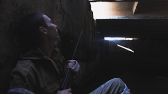 man in brown jacket holding stick