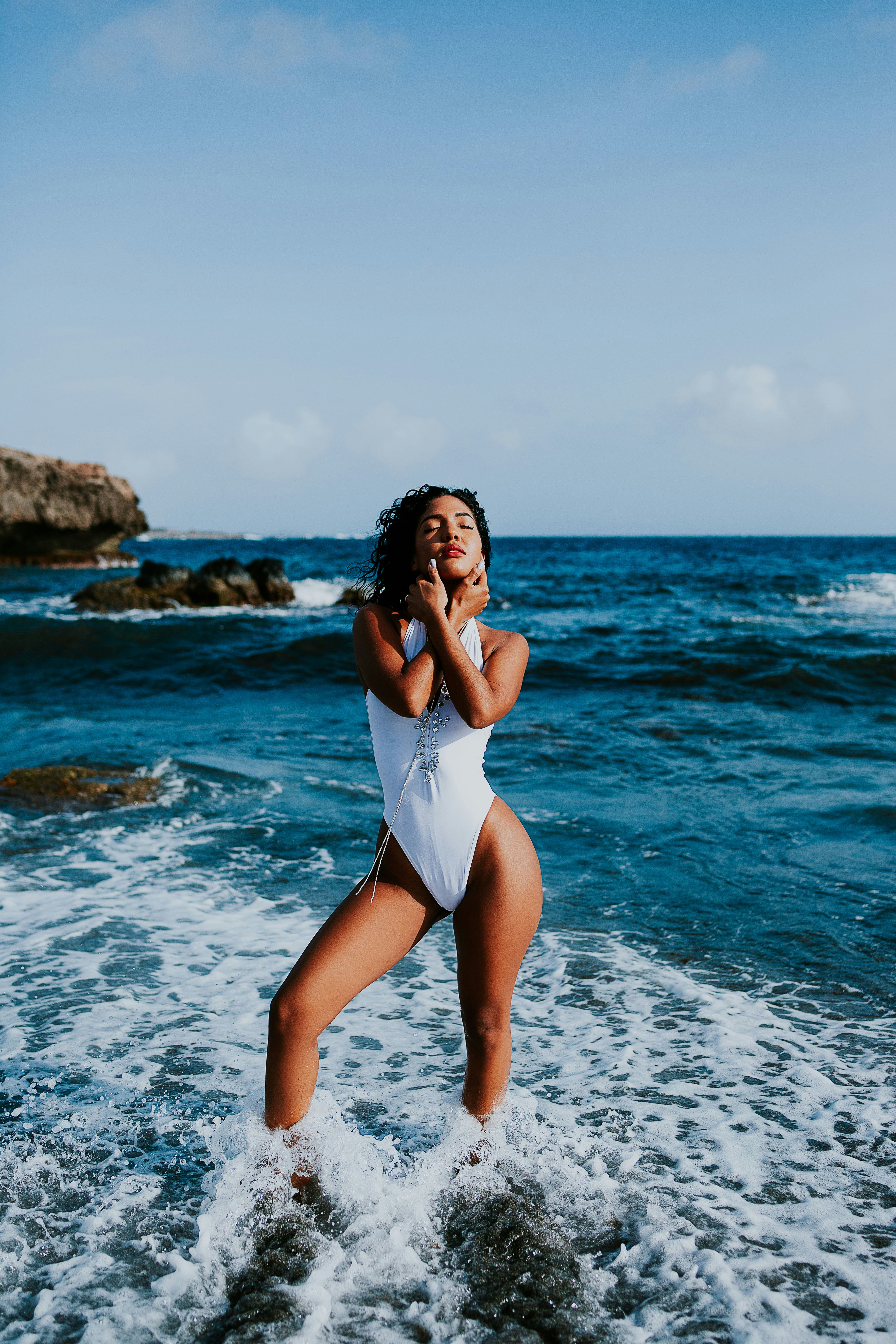 woman in white swimsuit standing on beach during daytime