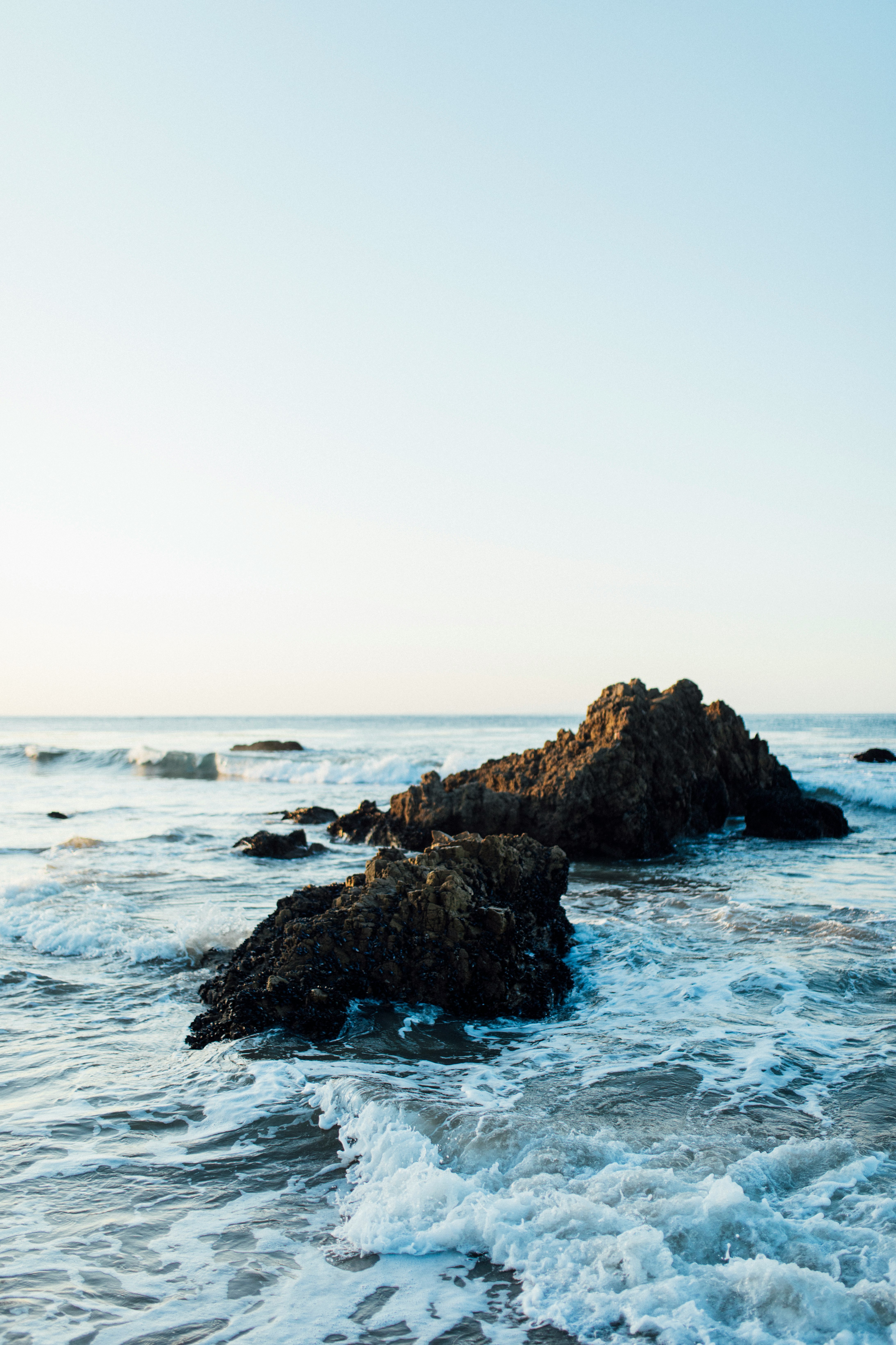 brown rock formation on sea during daytime