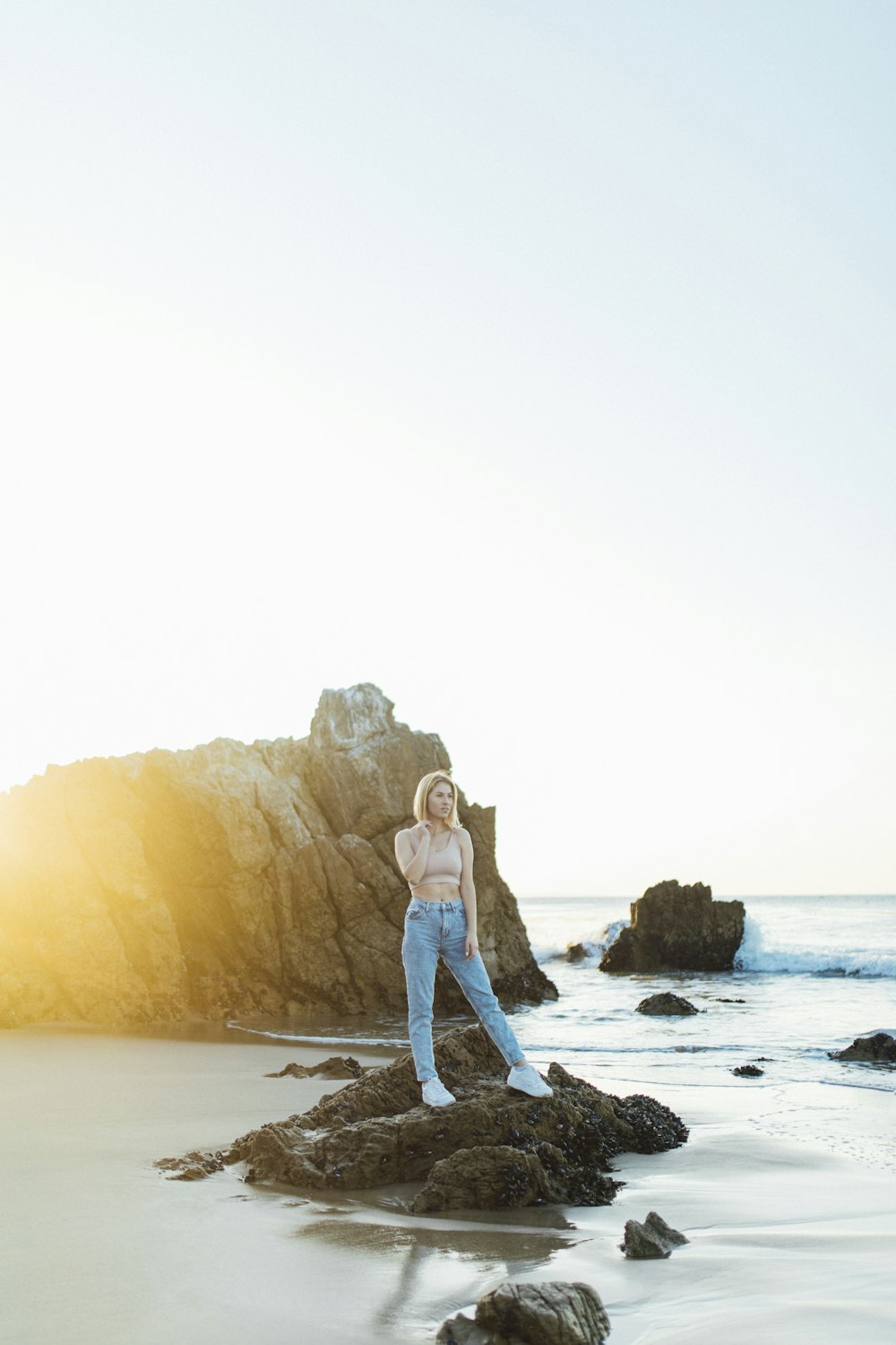 couple standing on rock formation near body of water during daytime