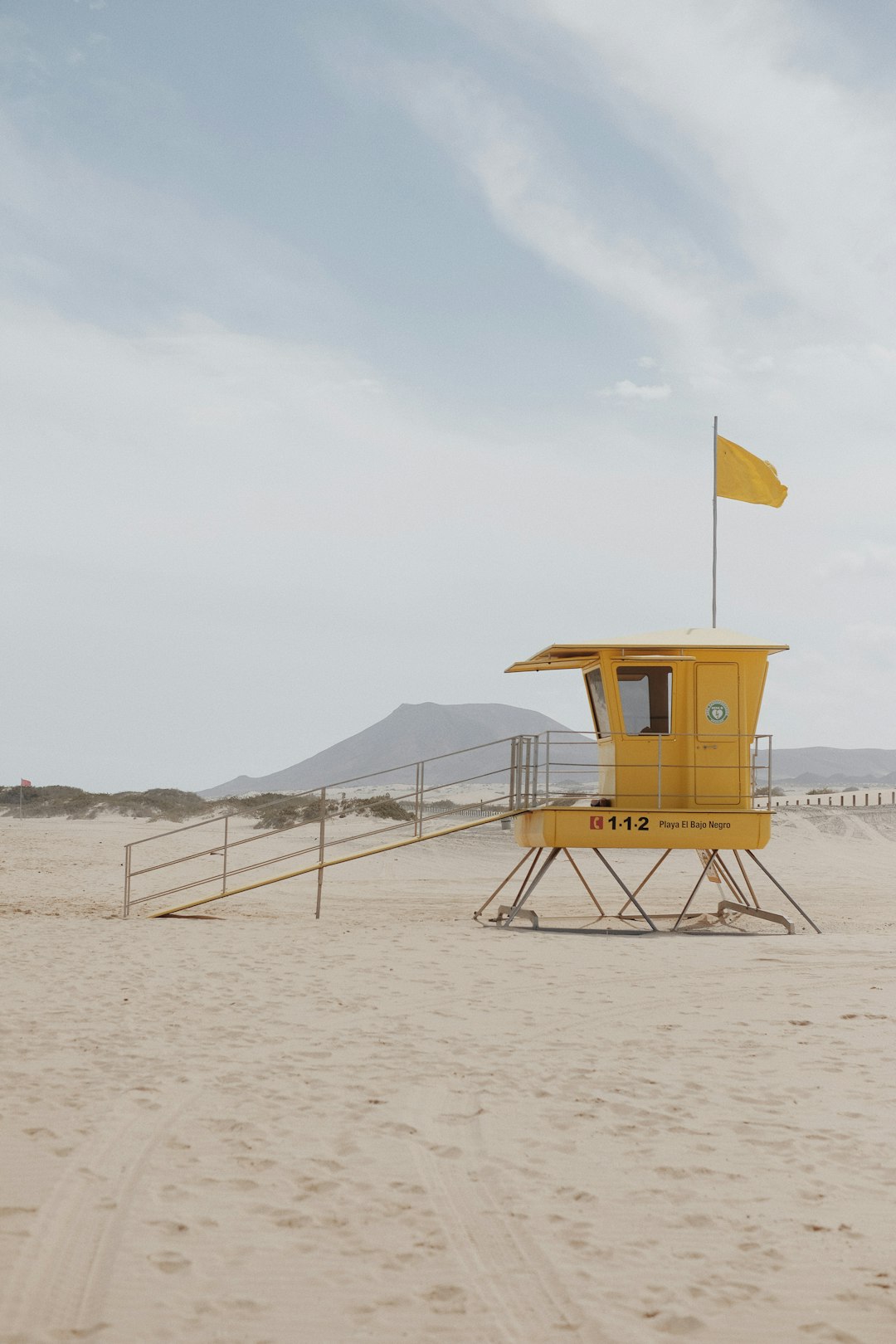 brown wooden chair on brown sand during daytime