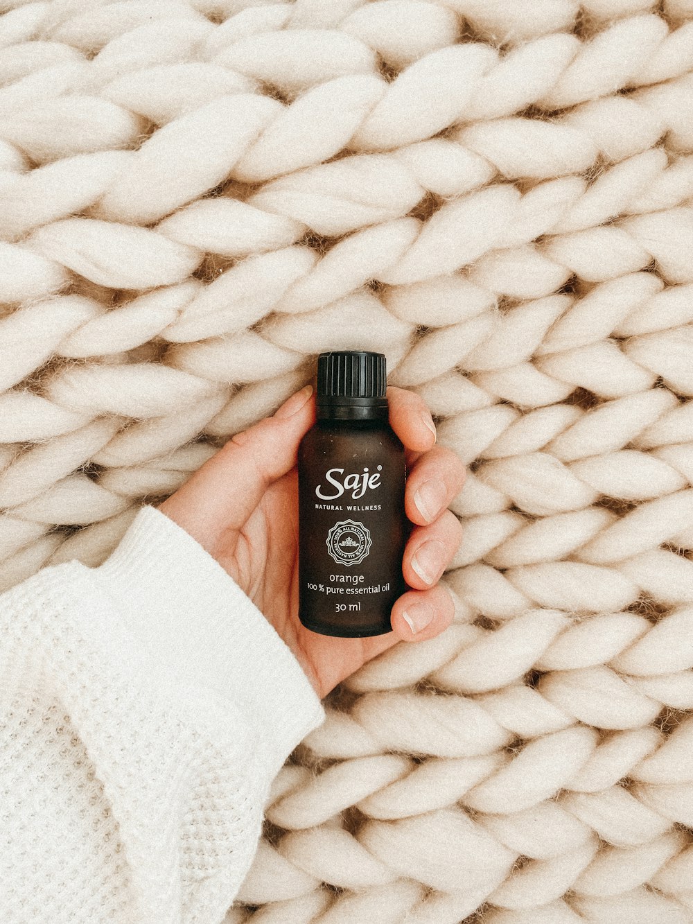 black and brown plastic bottle on white textile