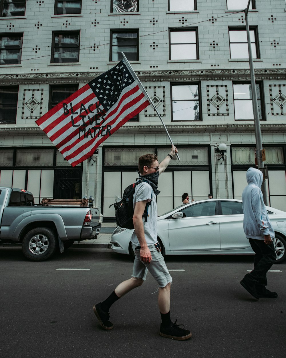 man in white t-shirt holding us a flag