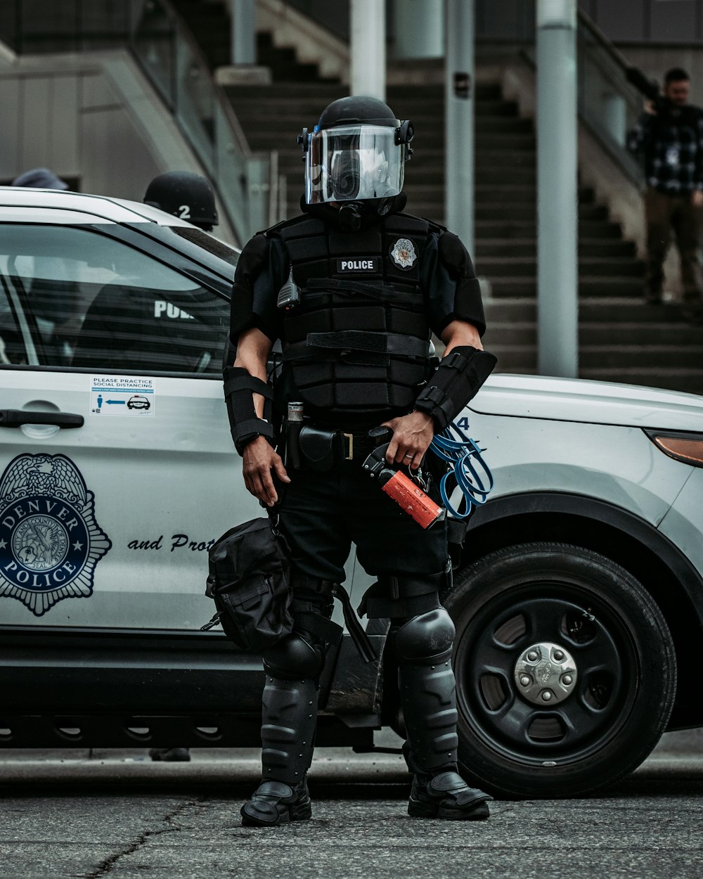 man in black helmet and black helmet standing beside white car during daytime