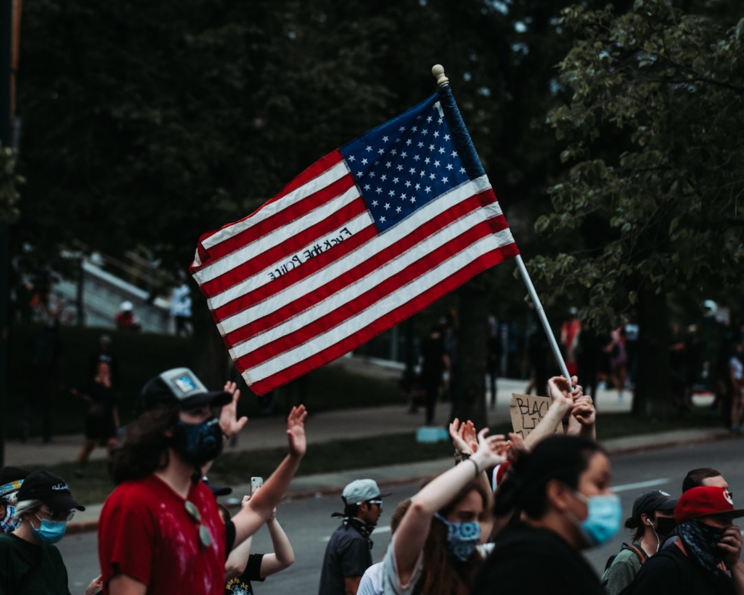 people holding flag of us a during daytime