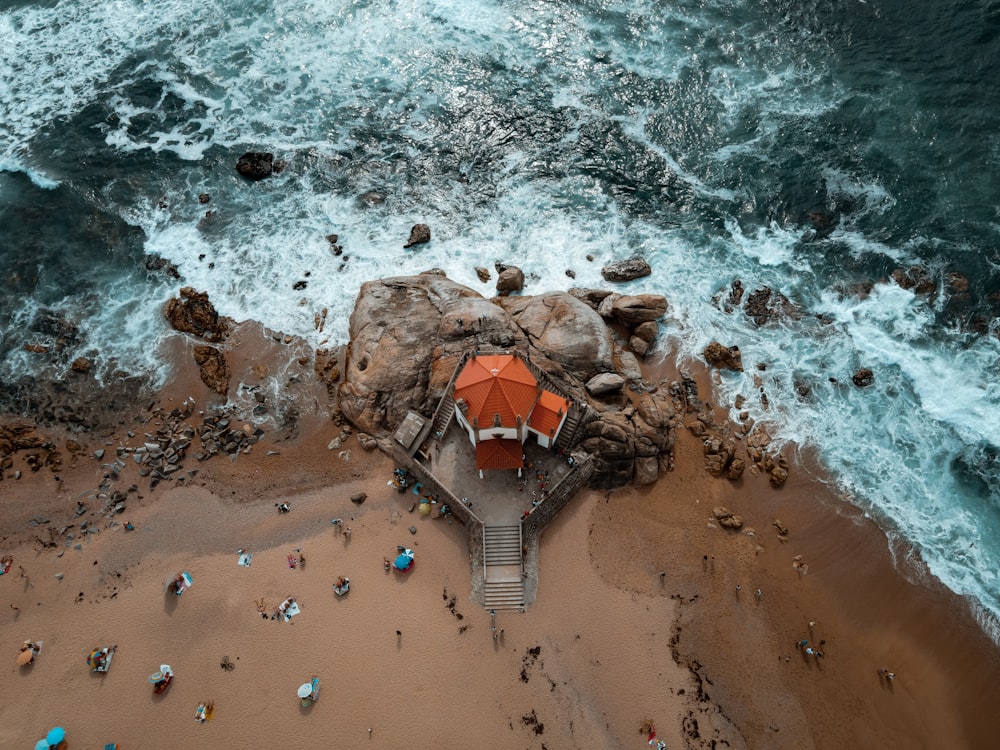 Braunes und weißes Holzhaus am braunen Sandstrand tagsüber