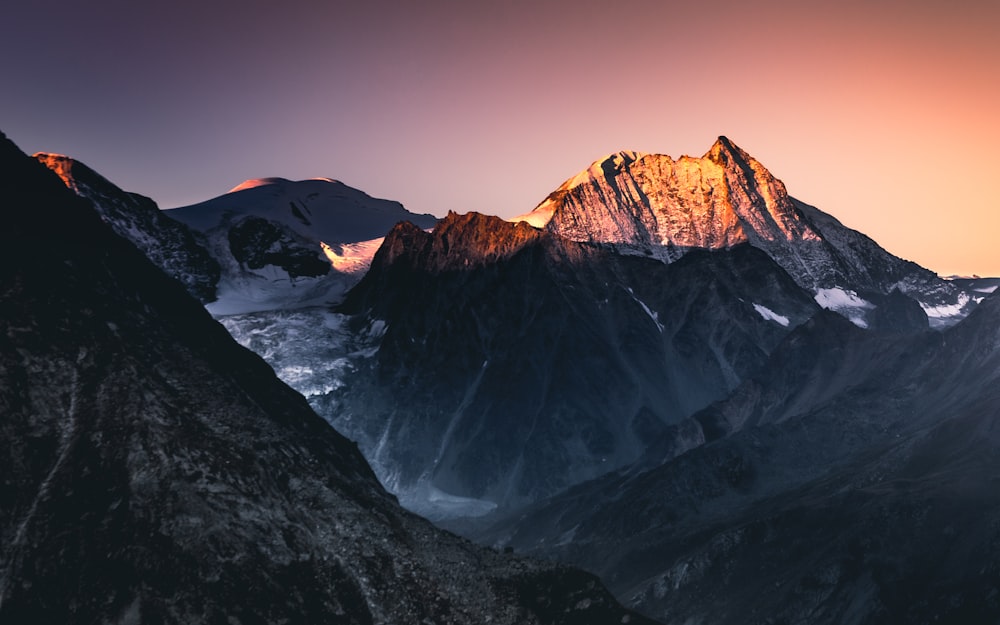 Schwarze und weiße Berge unter blauem Himmel tagsüber