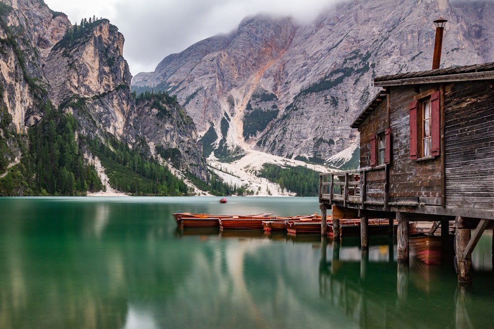 Maison en bois brun sur le lac près de la montagne pendant la journée