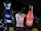 A bottle of 1800 Silver Tequila, an ice-filled crystal glass with a frothy pink drink garnished with a lime slice, and a bottle of Jarritos Guava soda are placed on a dark surface. Lime slices and white shredded pieces are scattered around.