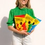 woman in green and yellow crew neck t-shirt holding yellow and red happy birthday banner