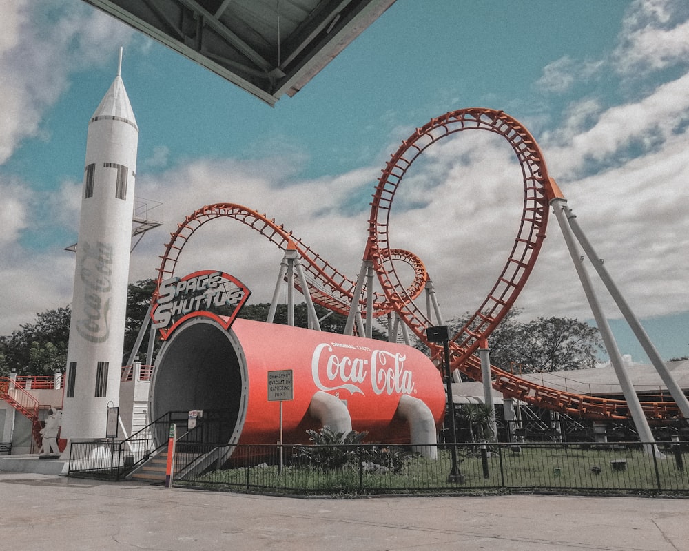 a giant coca cola rocket sitting in front of a building