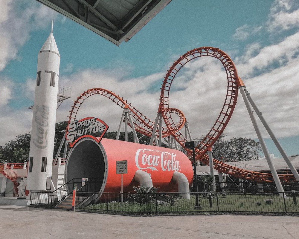 Une fusée géante de Coca Cola assise devant un immeuble