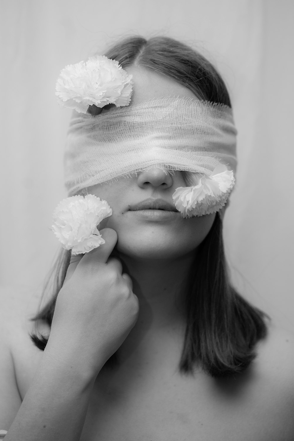 grayscale photo of woman with white flower on her head