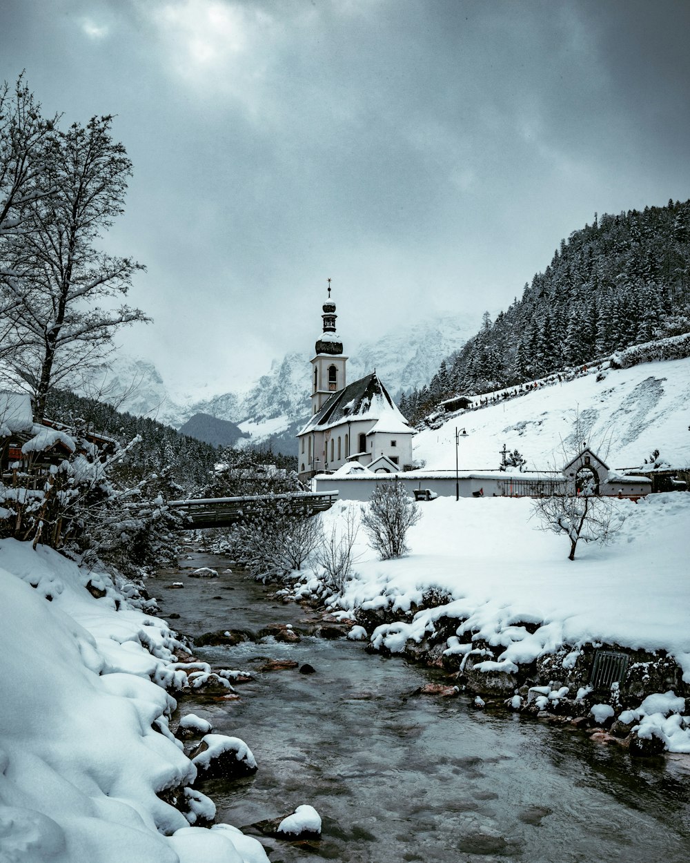 Weißes und braunes Haus in der Nähe von Bäumen und Fluss während des Tages