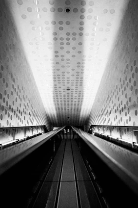 grayscale photo of a escalator