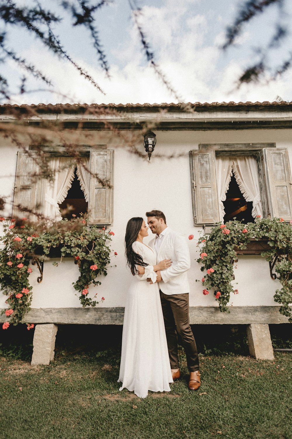 woman in white wedding gown standing beside man in white suit