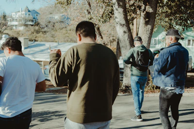 Group of people in casual, unstamped clothing walking down a city street.
