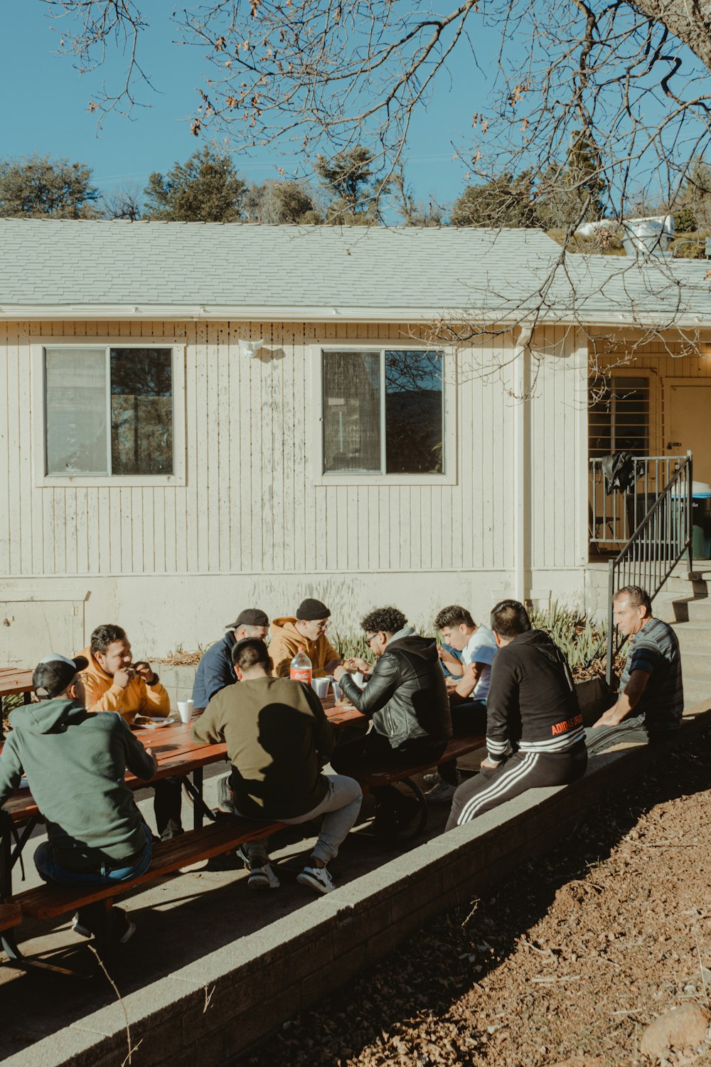 group of people sitting on brown wooden bench