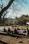A group of friends laughing around a picnic table.