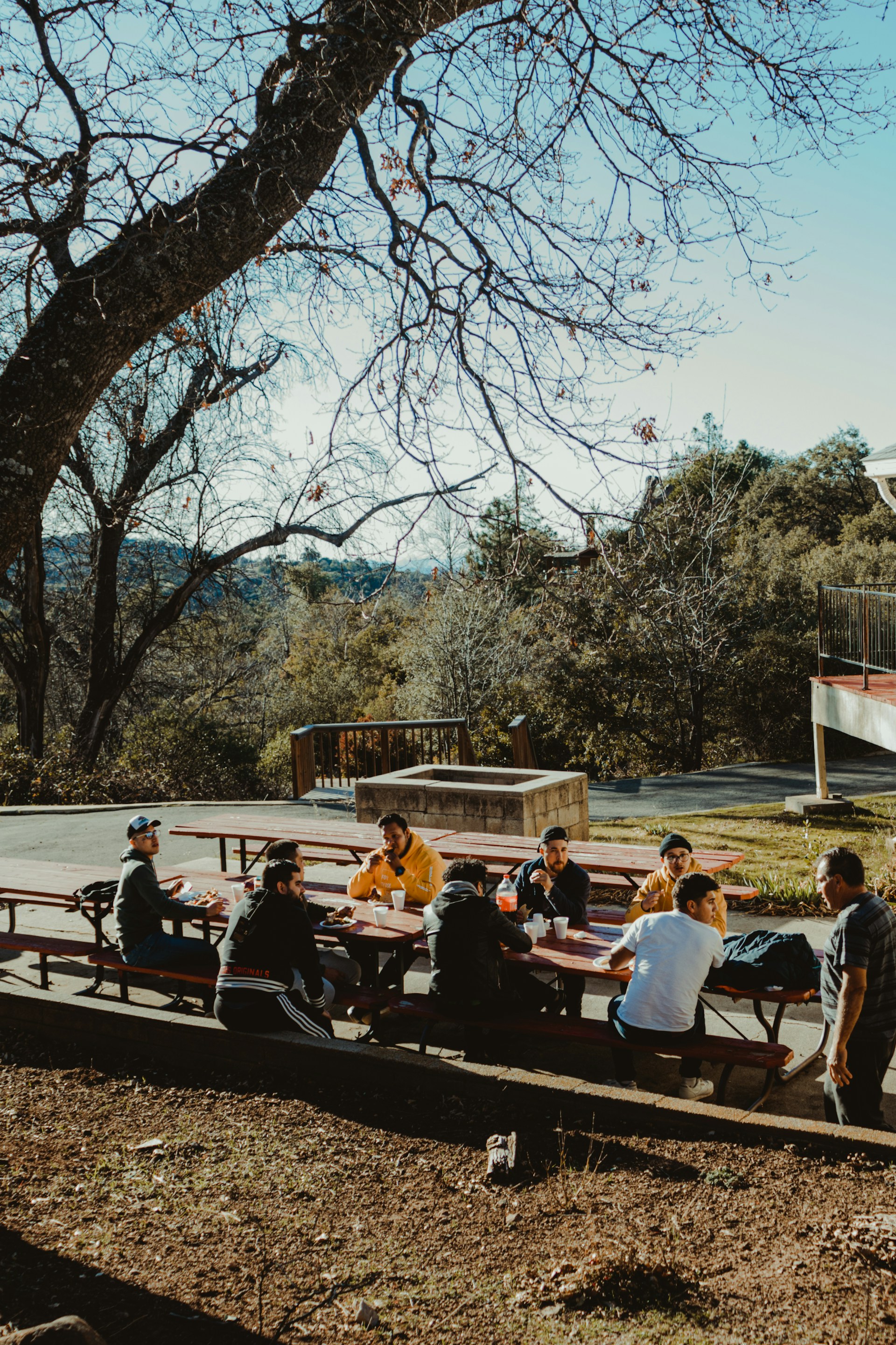 A family gathered around a picnic table, laughing and enjoying a sunny afternoon.