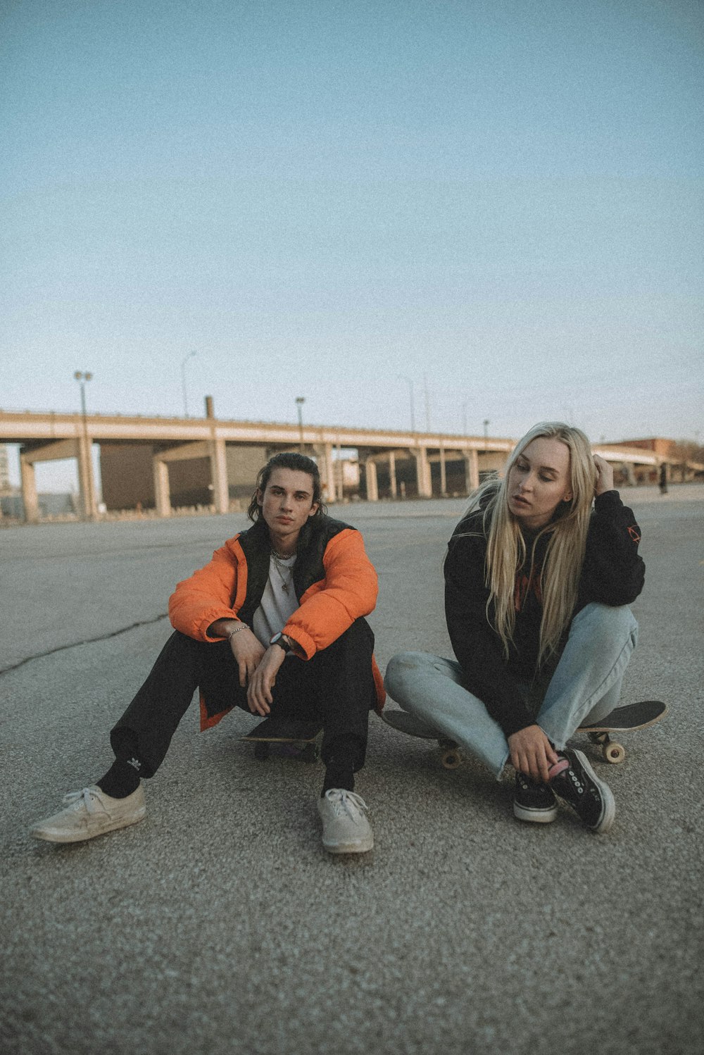 3 women sitting on gray concrete floor during daytime