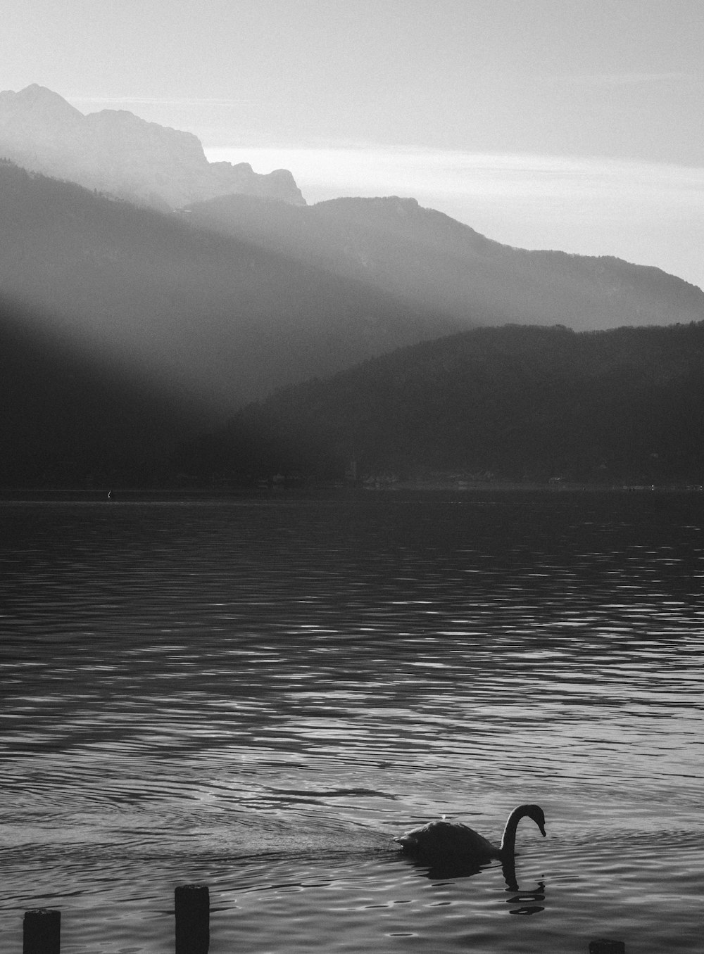 grayscale photo of body of water near mountain