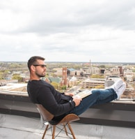 man in black long sleeve shirt sitting on chair during daytime